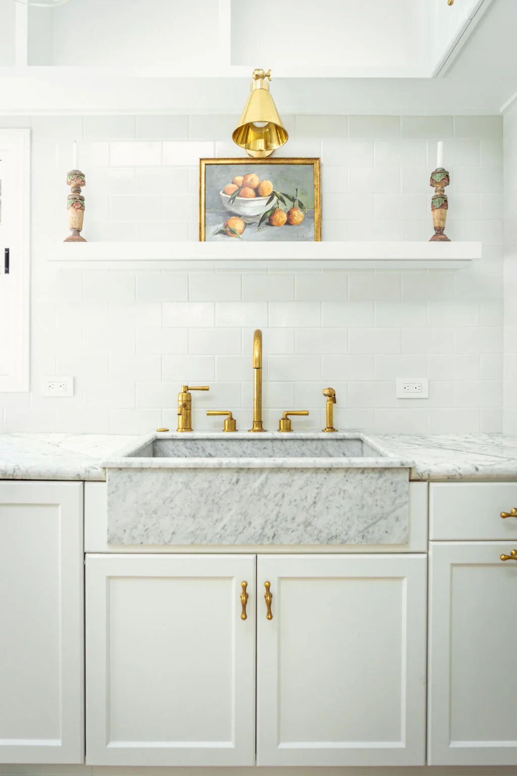 Marble apron sink with unlacquered brass Waterworks fixtures and floating shelf