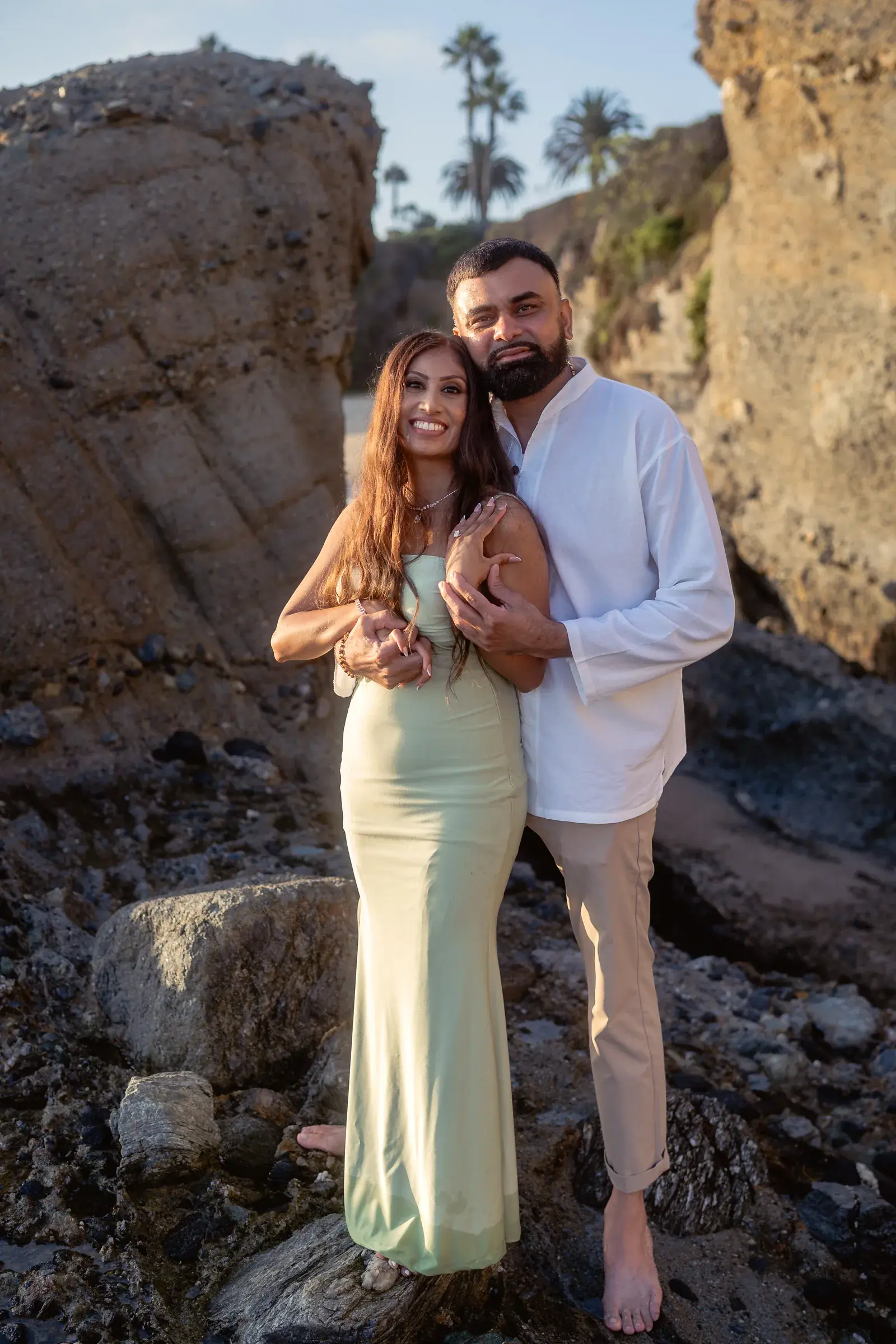 Engagement portrait of Ronak and Khushbu between the rock formations at Treasure Island Beach