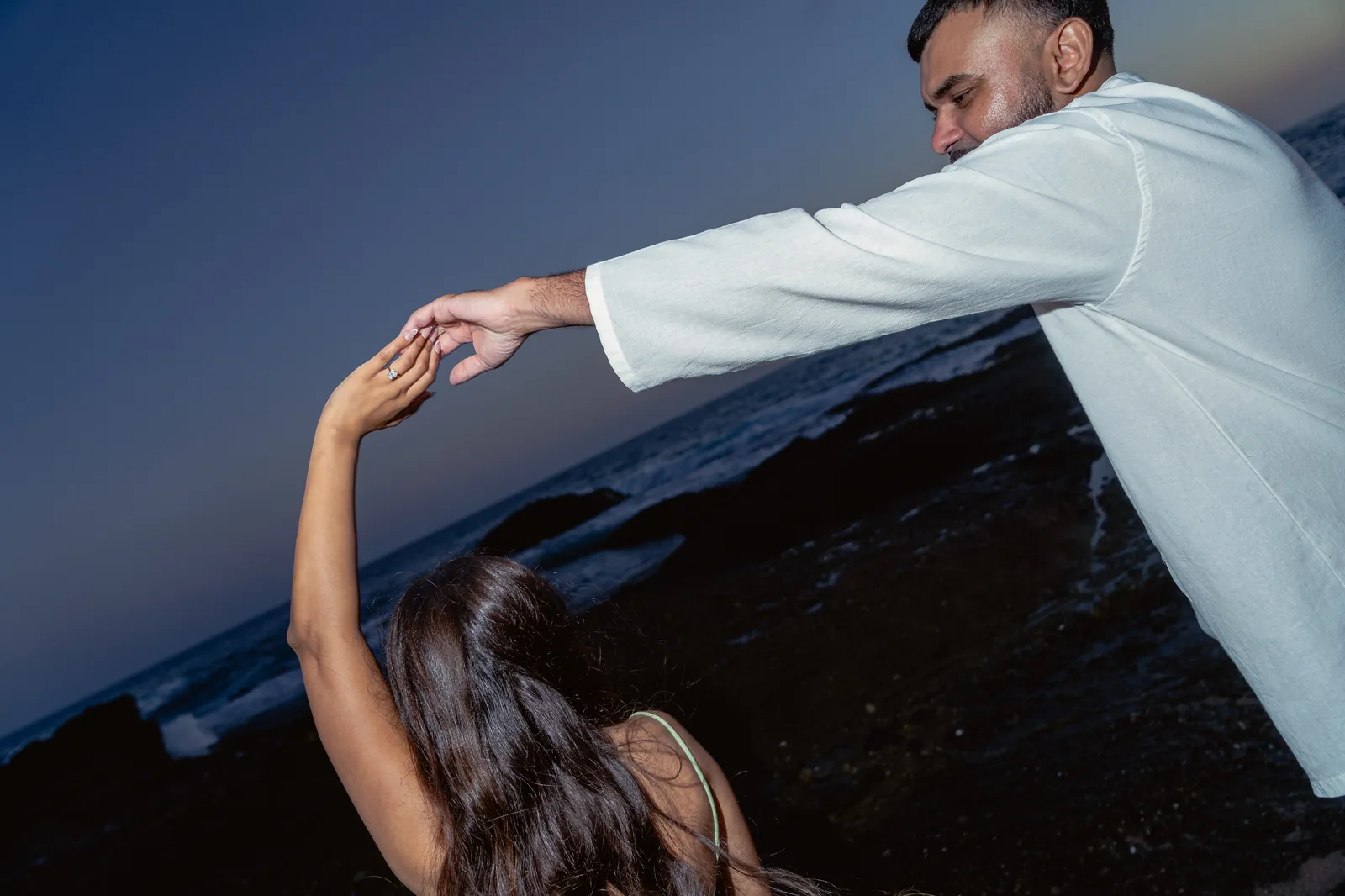 Ronak twirling Khushbu at blue hour on the rocks in Laguna Beach